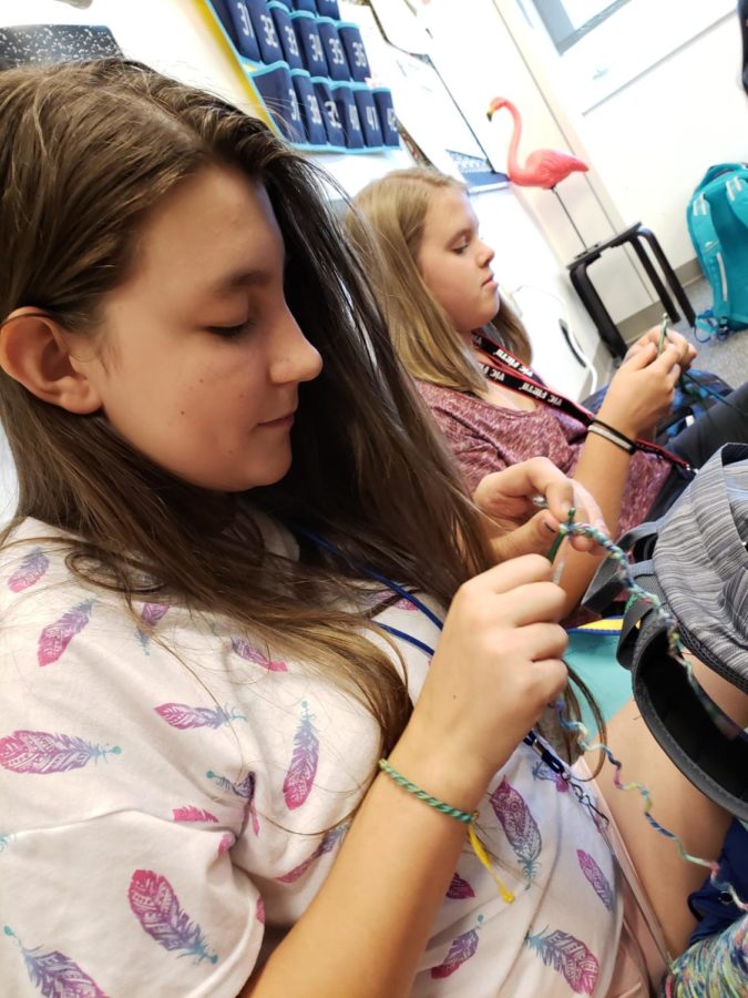 Caption: Stella Olsen (10) and Juliana Brady (9) enjoying eating lunch and crocheting in Mrs. Binion’s room.