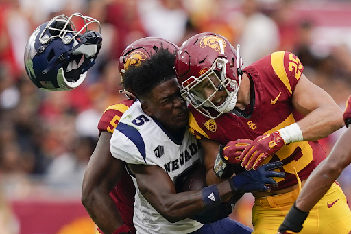 Wide receiver Dalevon Campbell (5) loses his helmet after being hit by Southern California linebacker Tackett Curtis (25).